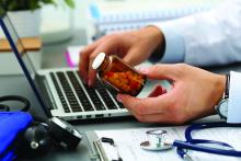 A doctor holds a bottle of pills